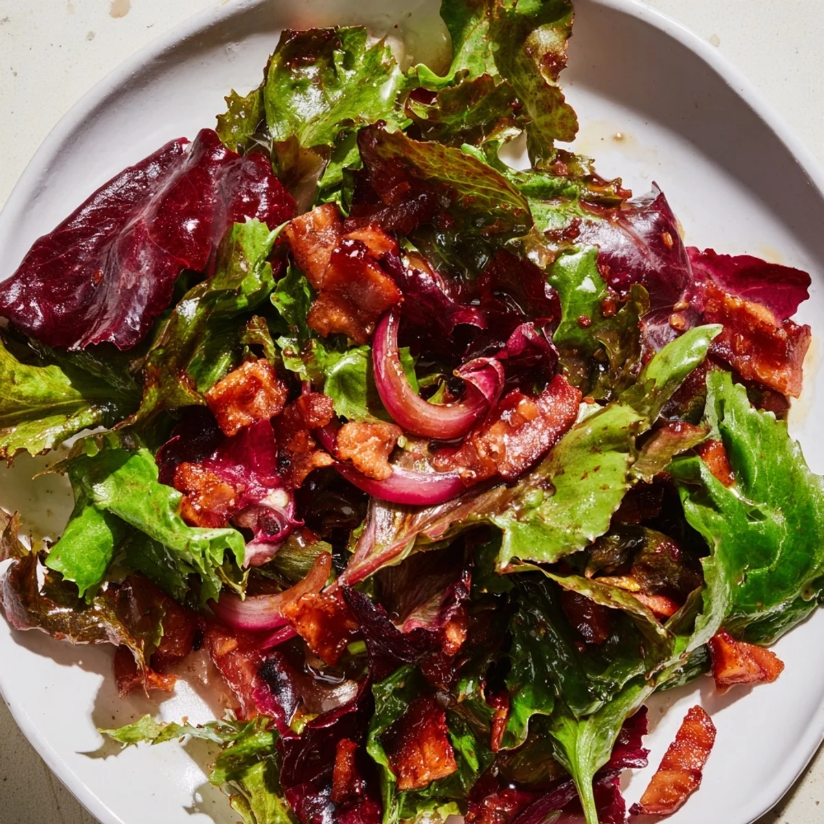 A close-up of a Bitter Greens Salad with Warm Bacon Dressing, a savory, inviting meal.