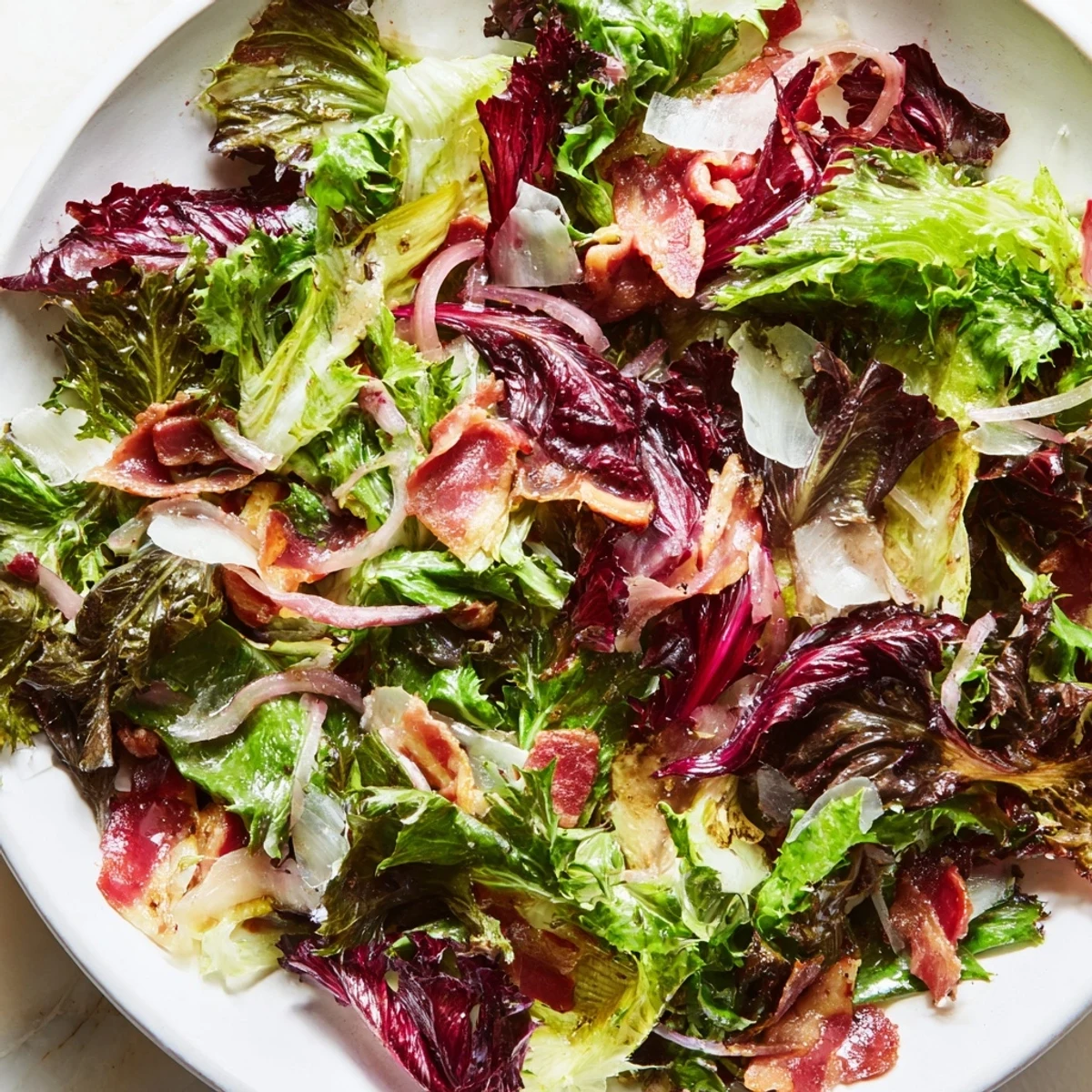 Golden bacon bits top the fresh Bitter Greens Salad with Warm Bacon Dressing, ready to serve.