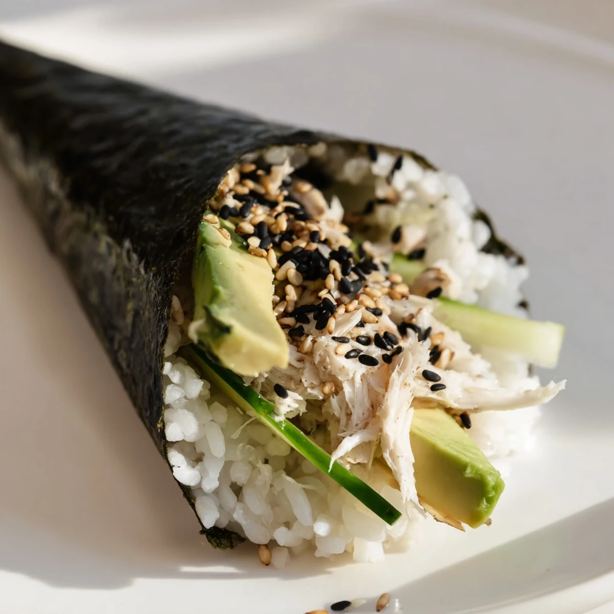 Freshly rolled sushi rice hand roll with julienned cucumber and avocado, served with soy sauce and wasabi. 