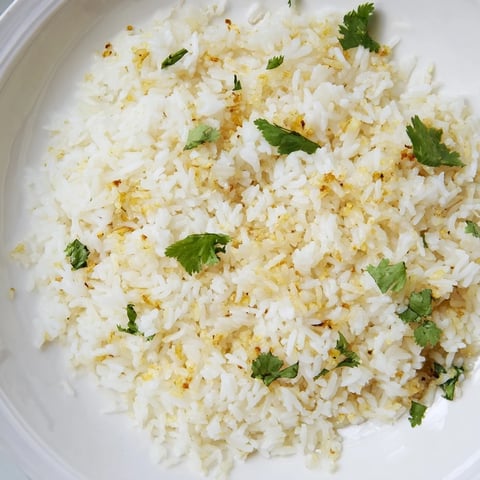 Fluffy, aromatic jasmine rice infused with golden garlic oil, glistening in a bowl for a perfect side dish.  