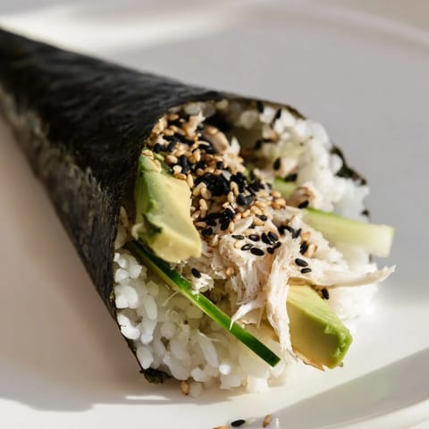 Freshly rolled sushi rice hand roll with julienned cucumber and avocado, served with soy sauce and wasabi. 