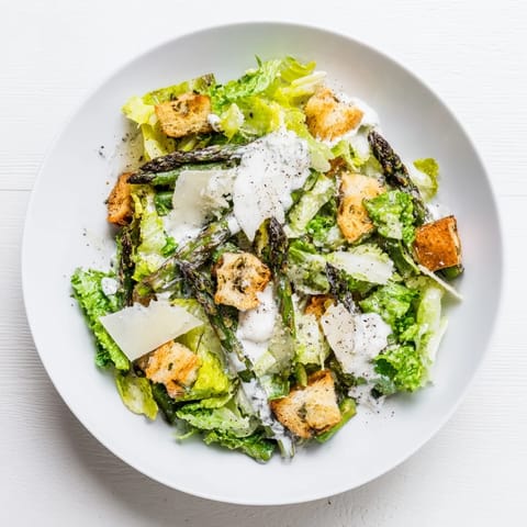 Crispy roasted asparagus and golden homemade croutons top a bed of romaine in this vibrant Roasted Asparagus Caesar Salad.