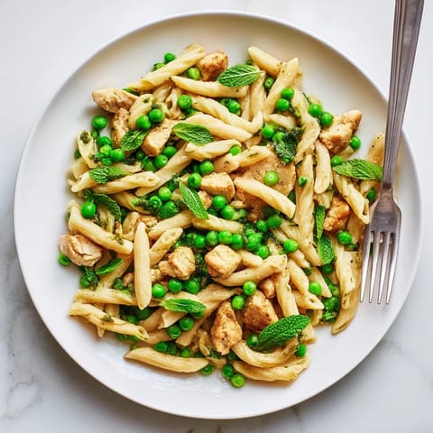 Golden penne pasta tossed with tender chicken, sweet green peas, and fresh mint in a bright lemon sauce.