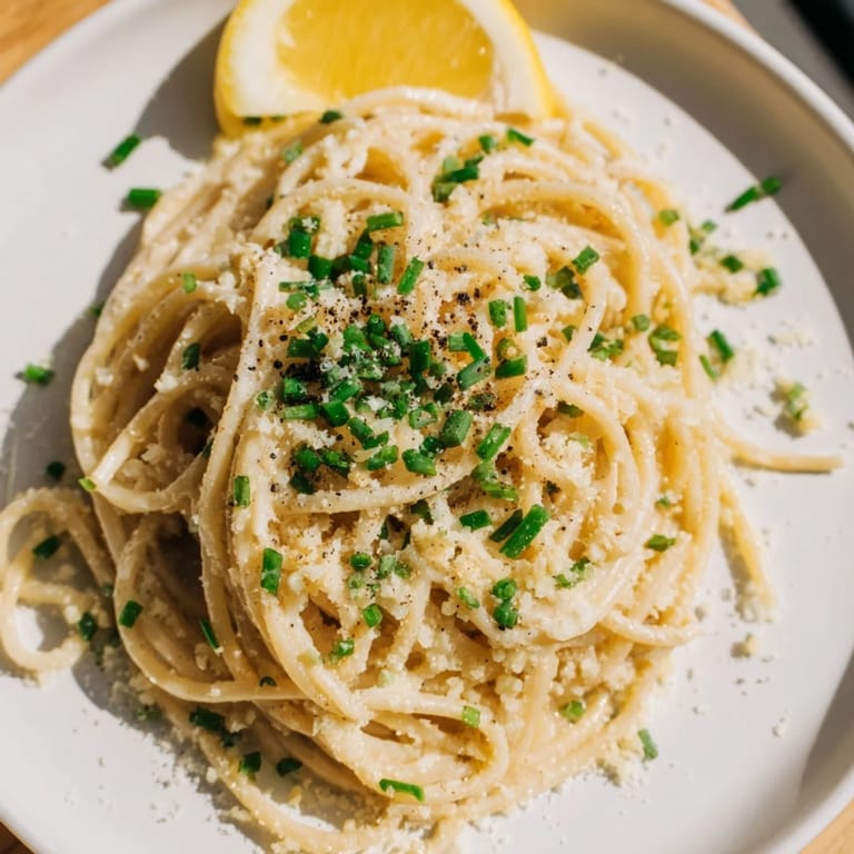 Flavorful Miso Butter Pasta with garlic, ready to eat, topped with Parmesan and fresh green herbs.