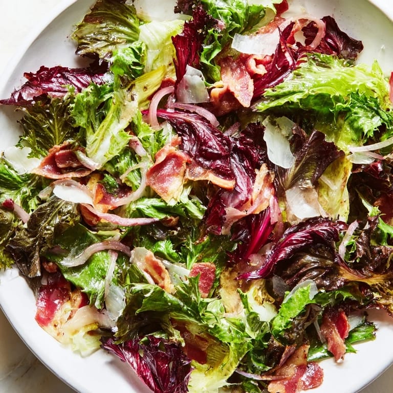 Golden bacon bits top the fresh Bitter Greens Salad with Warm Bacon Dressing, ready to serve.