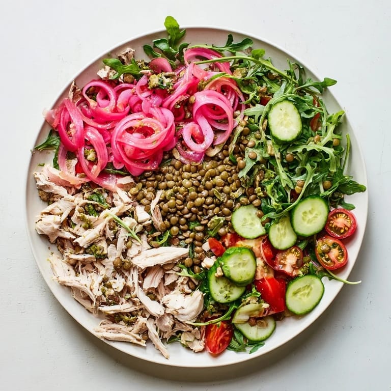 Bright bowl of Lentil & Chicken Spring Salad with colorful pickled onions, cherry tomatoes, and fresh greens ready to serve.