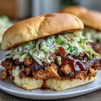 Juicy BBQ chicken sliders topped with tangy coleslaw, served on soft slider buns for a festive 4th of July feast.