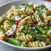 Vibrant spring pasta salad with radishes, asparagus, and lemon vinaigrette—perfect for light lunches or picnics.